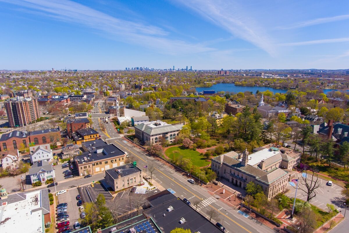 Arlington historic town center aerial view on Massachusetts Avenue at Mystic Street and Broadway with Boston at the background, Arlington, Massachusetts