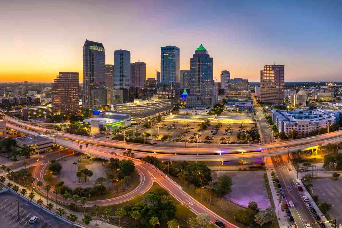 Night urban landscape of downtown district of Tampa in Florida, USA. American city skyline with brightly illuminated high commercial buildings and high speed highway road