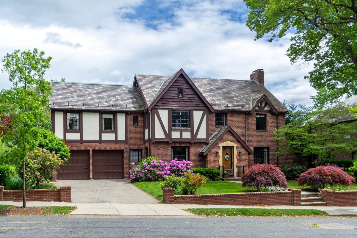 elegant tudor revival family house with brick facade and blooming garden in Brookline Massachusetts USA