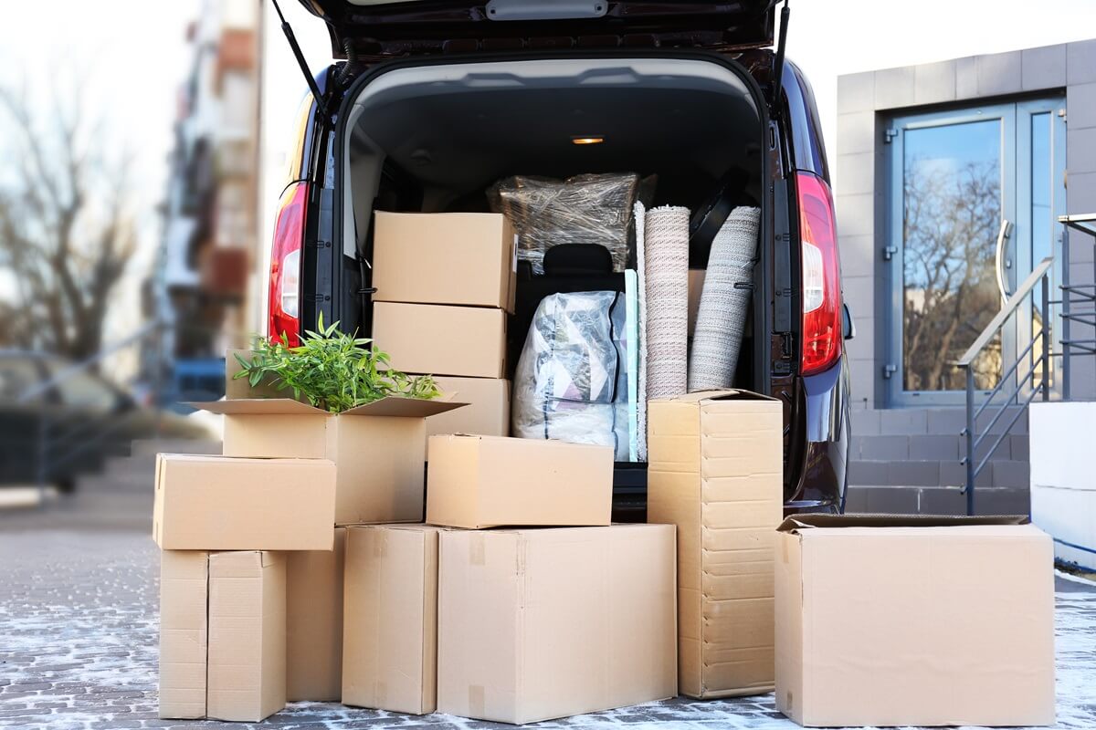 house moving concept cartoon boxes in a car trunk