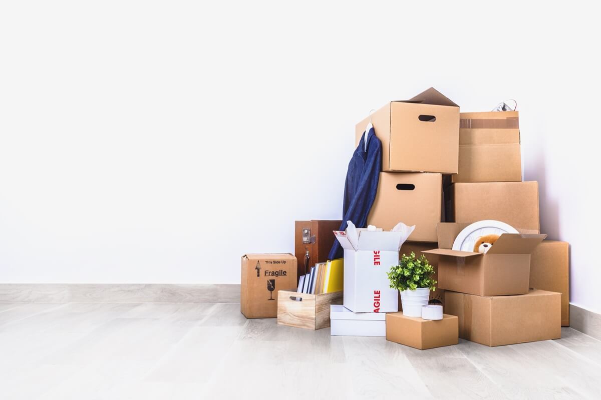 move cardboard boxes in empty room corner