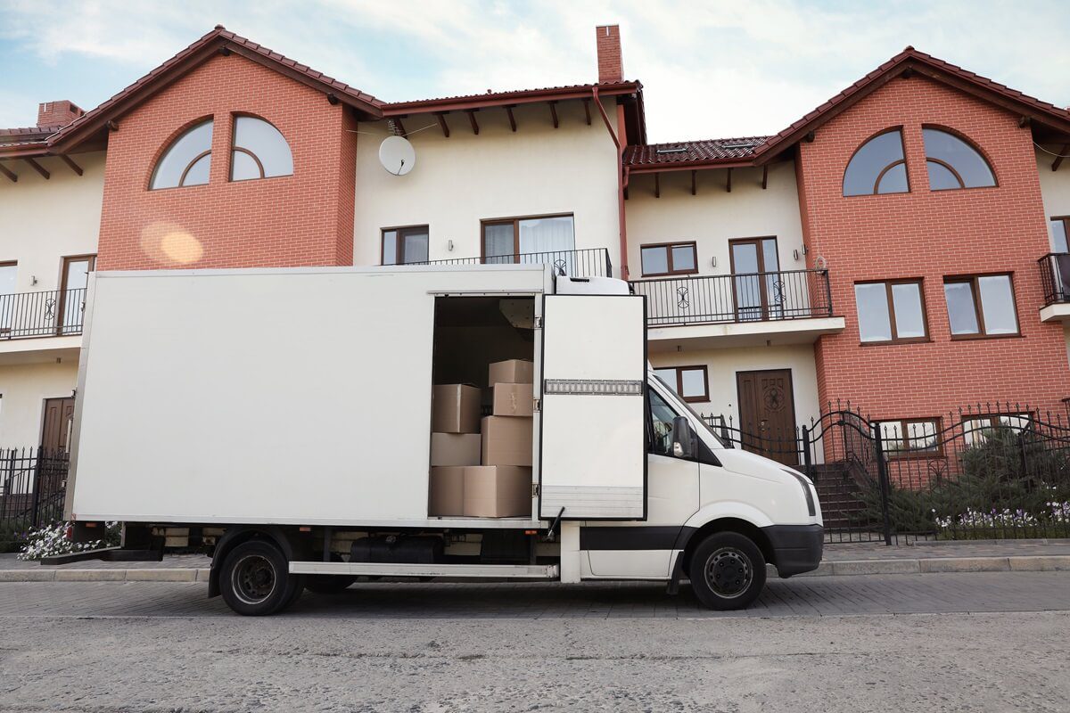 van full of moving boxes near new house
